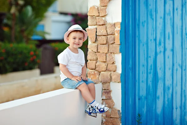 Niño pequeño con sombrero sentado en la casa en verano y sonriente —  Fotos de Stock