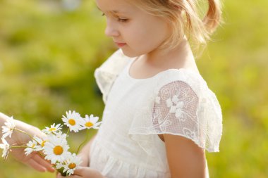 5 yıllık Beyaz giysili bir sarışın küçük kız portresi ve bir