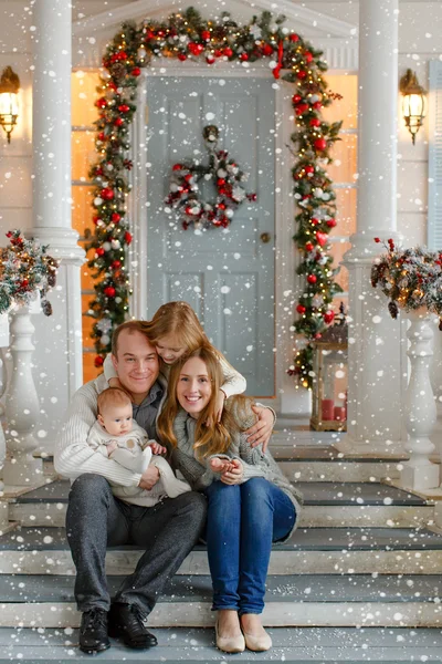 Belle famille heureuse avec des petites filles en tricot pull assis — Photo