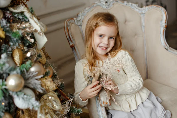 Adorable niña rubia con ojos azules sonriendo en el interio —  Fotos de Stock