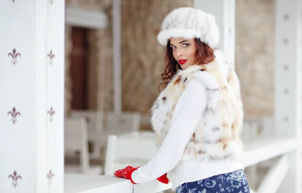 Bella ragazza bruna sexy con labbra rosse in un gilet di pelliccia e cappello — Foto Stock