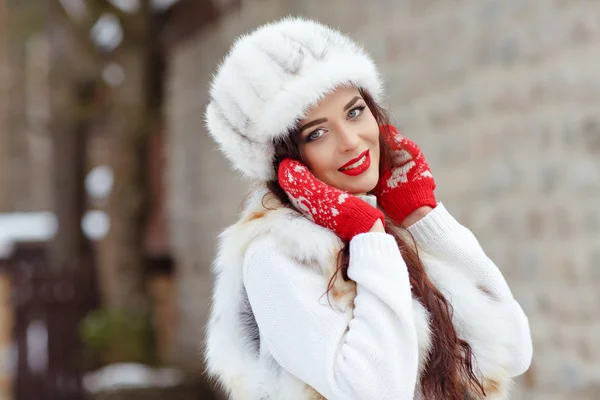 Belle fille brune sexy avec des lèvres rouges dans un gilet de fourrure et un chapeau — Photo