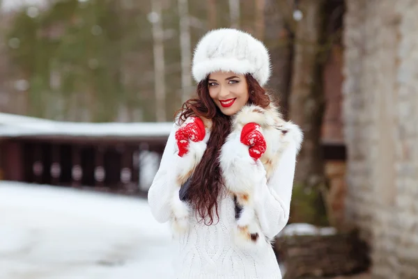 Hermosa chica morena sexy con labios rojos en un chaleco de piel y sombrero —  Fotos de Stock