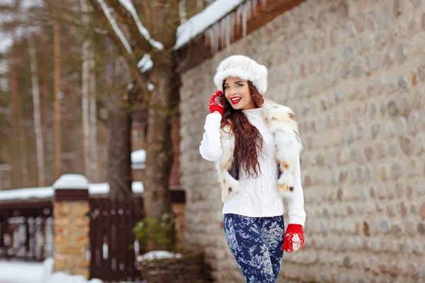 Belle fille brune aux cheveux longs en gilet de fourrure et chapeau de joie — Photo