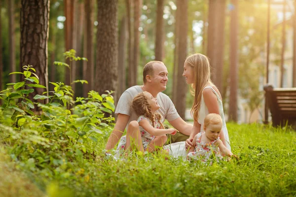 Famiglia madre, padre e due figlie bionde sedute in un su — Foto Stock