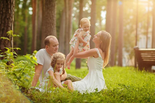 Familia - madre, padre y dos hijas rubias sentadas en su —  Fotos de Stock