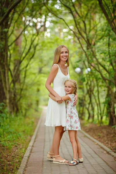 Slim rubia madre e hija en el bosque en el verano al sol —  Fotos de Stock