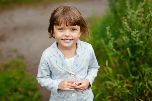 Gadis menawan kecil dengan mata coklat di latar belakang musim panas — Stok Foto