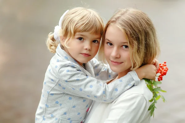 Twee kleine mooie meisjes zusters knuffel, close-up portret — Stockfoto