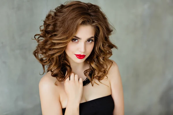 Portrait of a beautiful glamorous brunette with curly hair and bright makeup with red lipstick, close-up, beauty — Stock Photo, Image