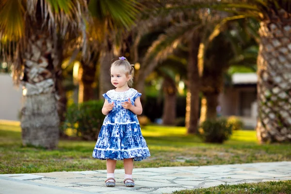 Portret van een meisje in een blauwe jurk op een achtergrond van palmbomen in Cyprus — Stockfoto
