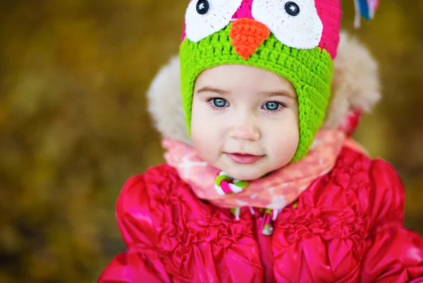 Little cute girl in a red jacket and hat with owl — Stock Photo, Image