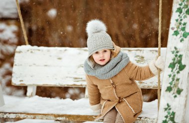 Çok güzel güzel kız çocuk bej bir palto ve bir gri şapka si