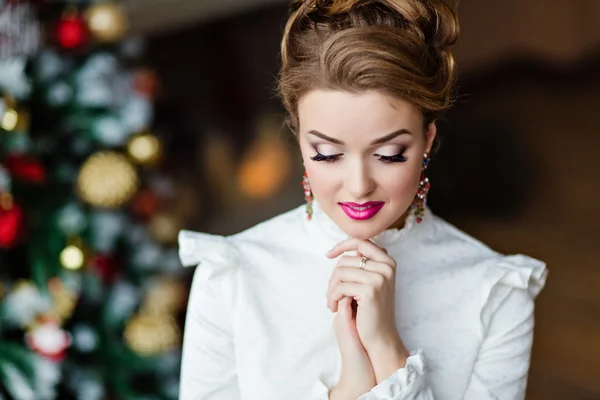 Portrait of a beautiful blonde girl in a white blouse with your eyes closed