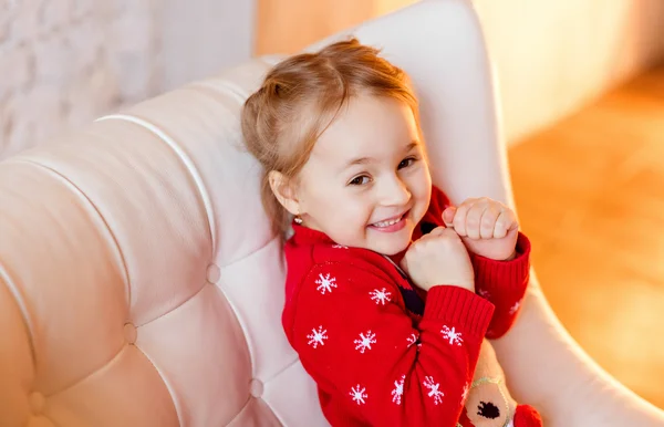 Fetiță copil cu ochi căprui zâmbește provocator, într-un roșu — Fotografie, imagine de stoc