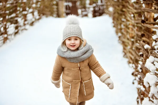 Zeer mooi mooi meisje kind in een beige vacht en een grijze hoed gaan — Stockfoto