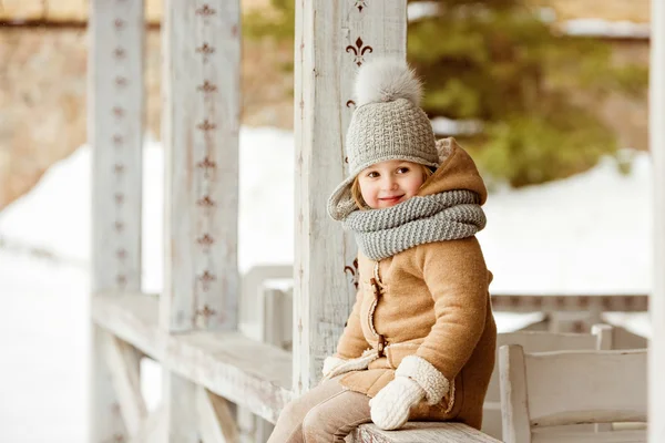 Very nice beautiful girl child in a beige coat and a gray hat si — Stock Photo, Image