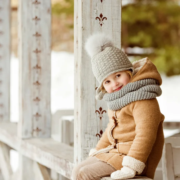 Very nice beautiful girl child in a beige coat and a gray hat si — Stock Photo, Image