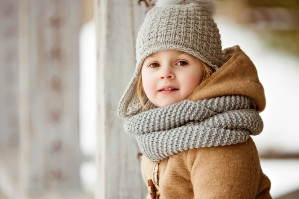 Portrait of a very cute beautiful girl child in a beige coat and — Stock Photo, Image