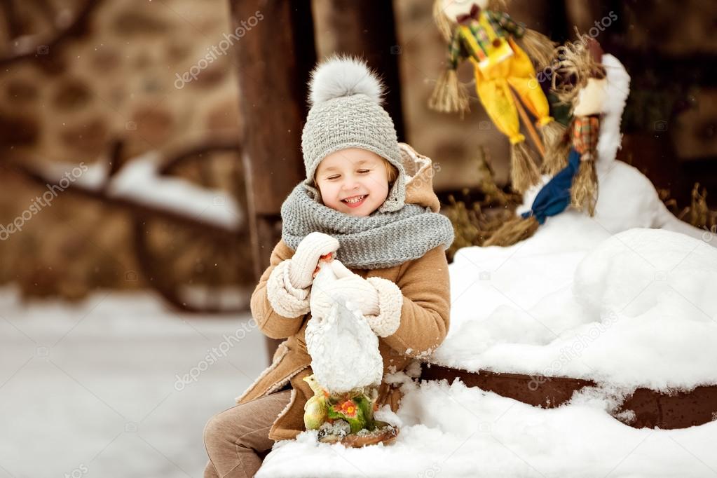 Very sweet and funny girl child in a beige coat sitting on the s