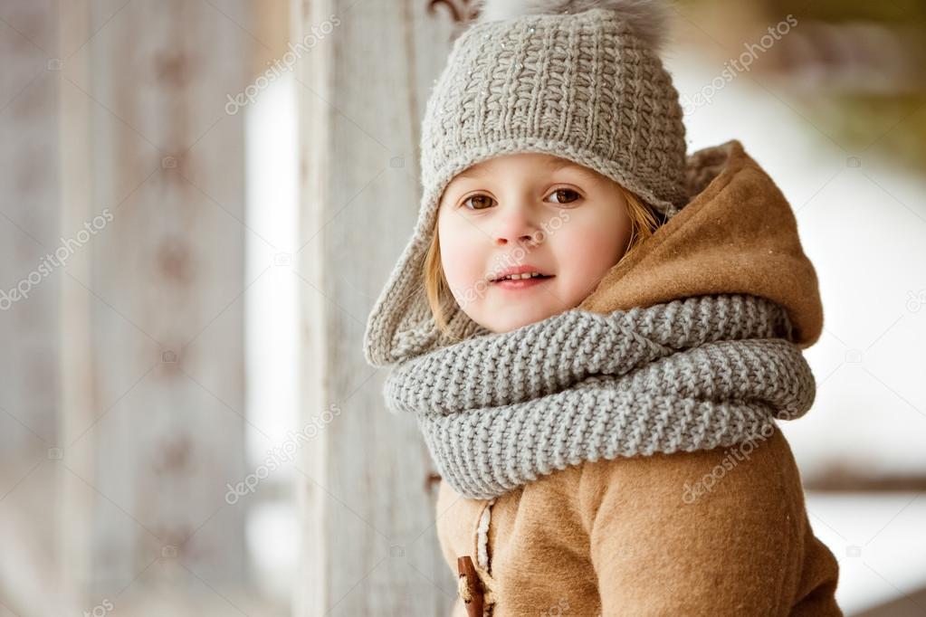 portrait of a very cute beautiful girl child in a beige coat and