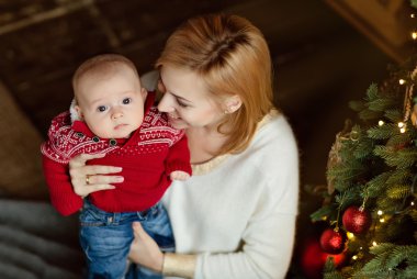 Küçük yürümeye başlayan çocuk oğlu anne sarışın beyaz kazaklı görünüyor 