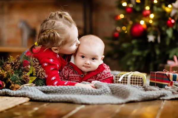 Liten pojke småbarn i en röd tröja kram hans äldre syster, ligg — Stockfoto