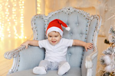 Bir sandalye aga üzerinde oturan kırmızı Santa şapkalar küçük sevimli bebeğim