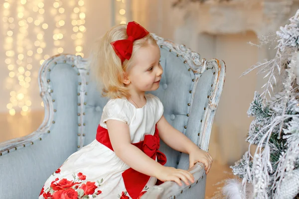 Pequena menina encantadora loira em um vestido vermelho está olhando para si — Fotografia de Stock