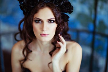 B üzerinde oturan siyah çiçek çelenk ile güzel esmer