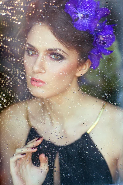 Sensual beautiful brunette woman with flowers in her hair at the — Stock Photo, Image