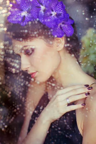 Sensual beautiful brunette woman with flowers in her hair at the — Stock Photo, Image