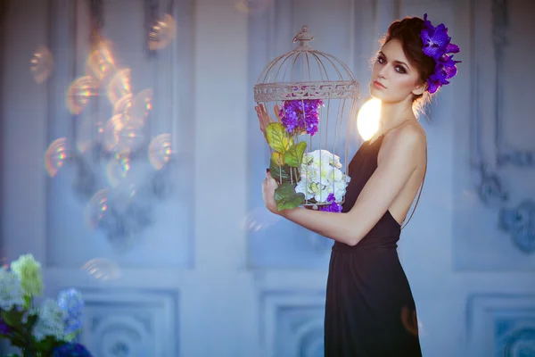 Very beautiful brunette woman with flowers in her hair holding c — Stock Photo, Image