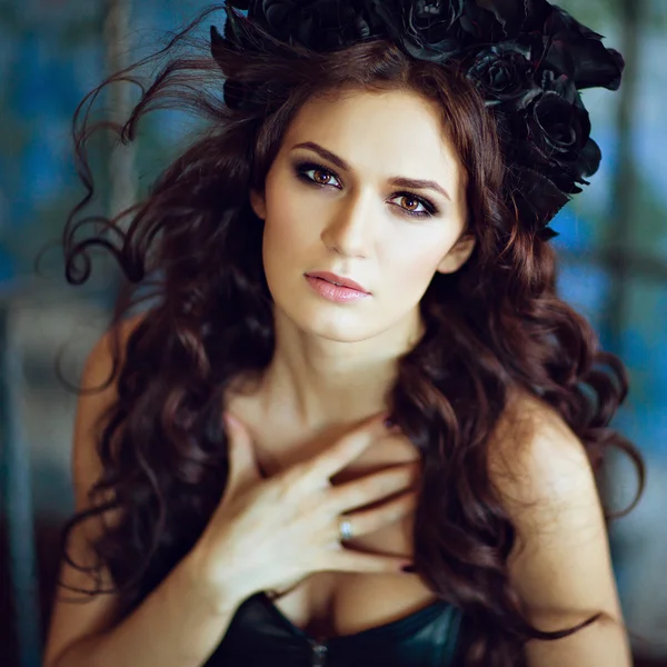 Hermosa morena sensual con una corona de flores negras sittin Fotos De Stock