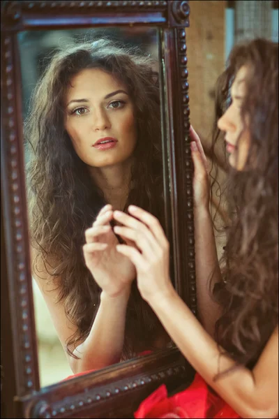 Sexy sensual very beautiful curly girl looks in the mirror Stock Picture