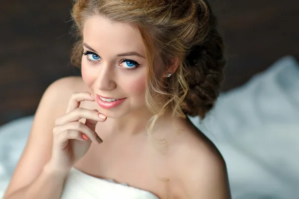 Retrato de uma menina com cabelos loiros grossos e olhos azuis em um vestido branco, close-up — Fotografia de Stock