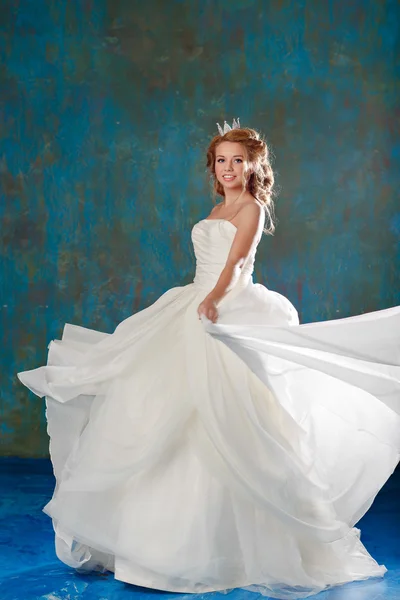 Retrato de una joven rubia con el pelo grueso chic, trenzado en una trenza, con un vestido blanco y una corona en la cabeza, como una princesa, una longitud completa — Foto de Stock