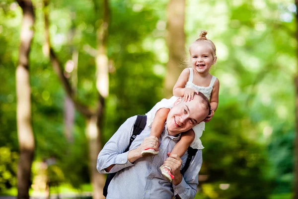 Папа держит свою дочь на плечах и счастливую улыбку — стоковое фото