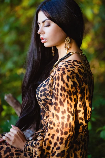 Portrait d'une belle fille brune sensuelle sexy aux cheveux longs en robe, profil et zoom jaune-noir léopard — Photo