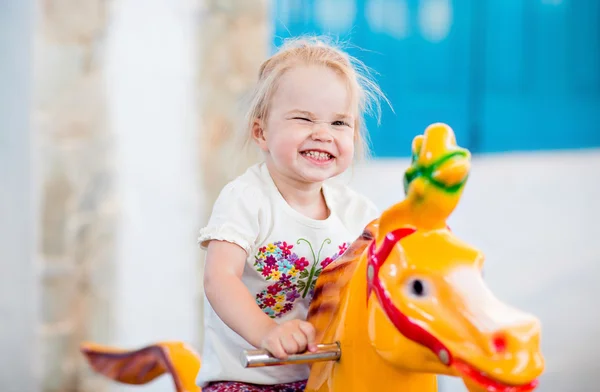 Emotional little girl riding on the carousel — Stockfoto