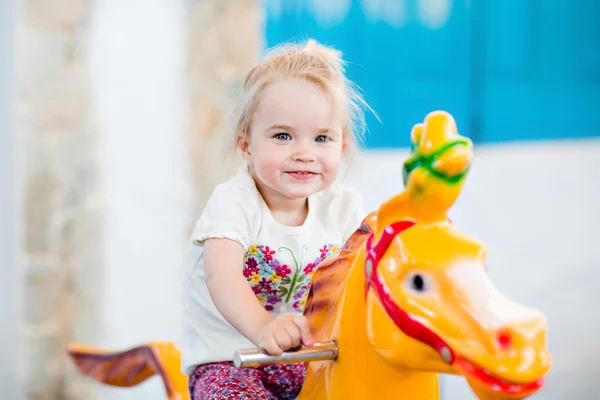 Fetiță zâmbitoare emoțională călare pe carusel — Fotografie, imagine de stoc