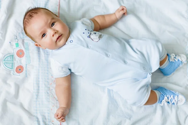 Portrait of a pretty little baby , lying on a light blanke — Stok fotoğraf