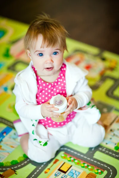 Charming little girl in sportswear holding a bottle — ストック写真