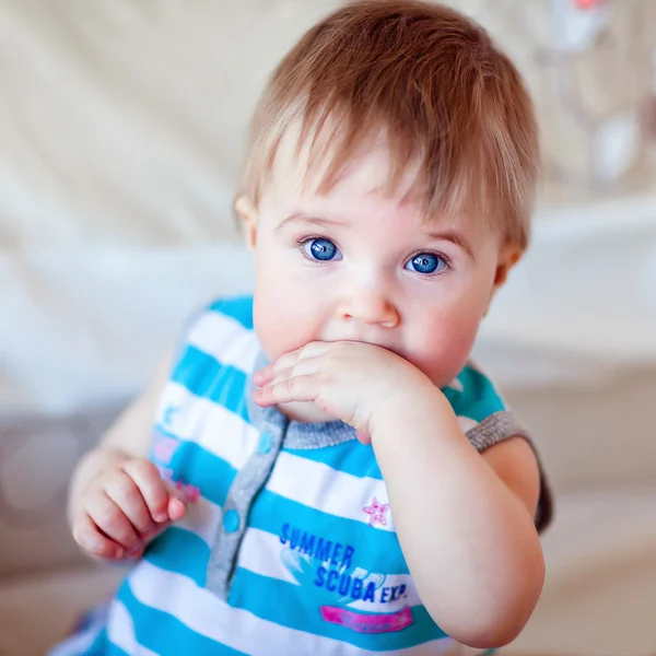 Menina de olhos azuis segurando a mão na boca — Fotografia de Stock
