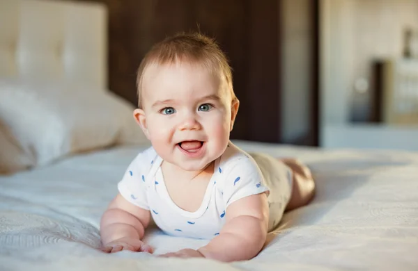 Muy lindo bebé niño acostado en la cama en un velo de luz sm — Foto de Stock