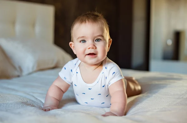 Muy lindo niño pequeño acostado en la cama sobre su barriga en un labio — Foto de Stock