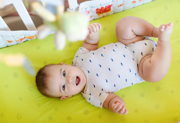 Un niño encantador acostado en la cama y sonriendo — Foto de Stock