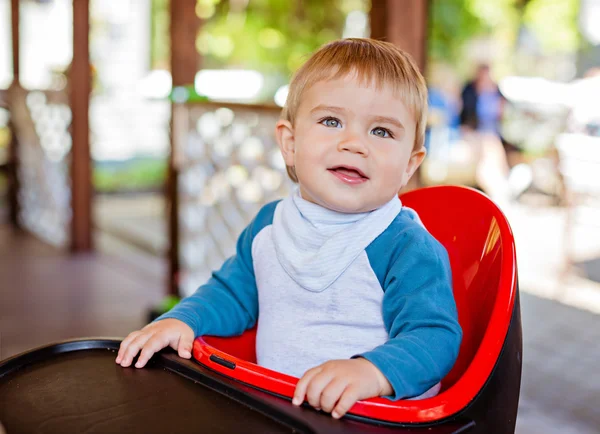 Muy lindo hermoso bebé niño sentado en el sillón negro —  Fotos de Stock