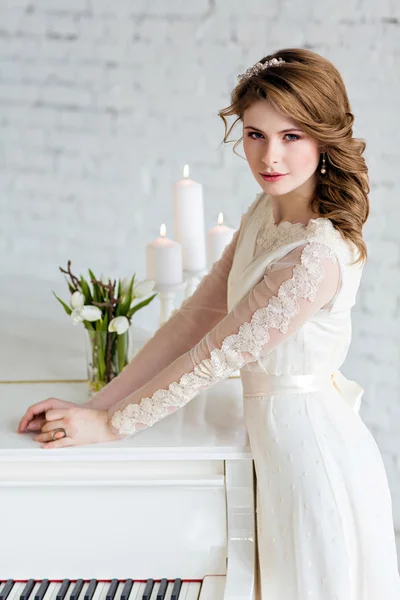 Hermosa novia chica sensual en un vestido de novia cuesta sobre whit — Foto de Stock