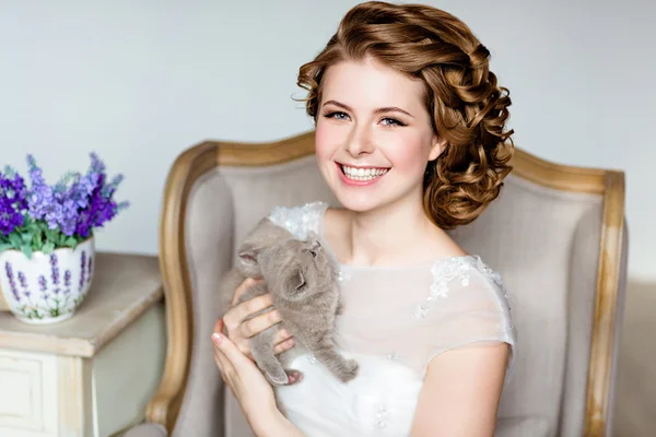 Hermosa chica sonriente feliz en un vestido de novia con una k gris —  Fotos de Stock